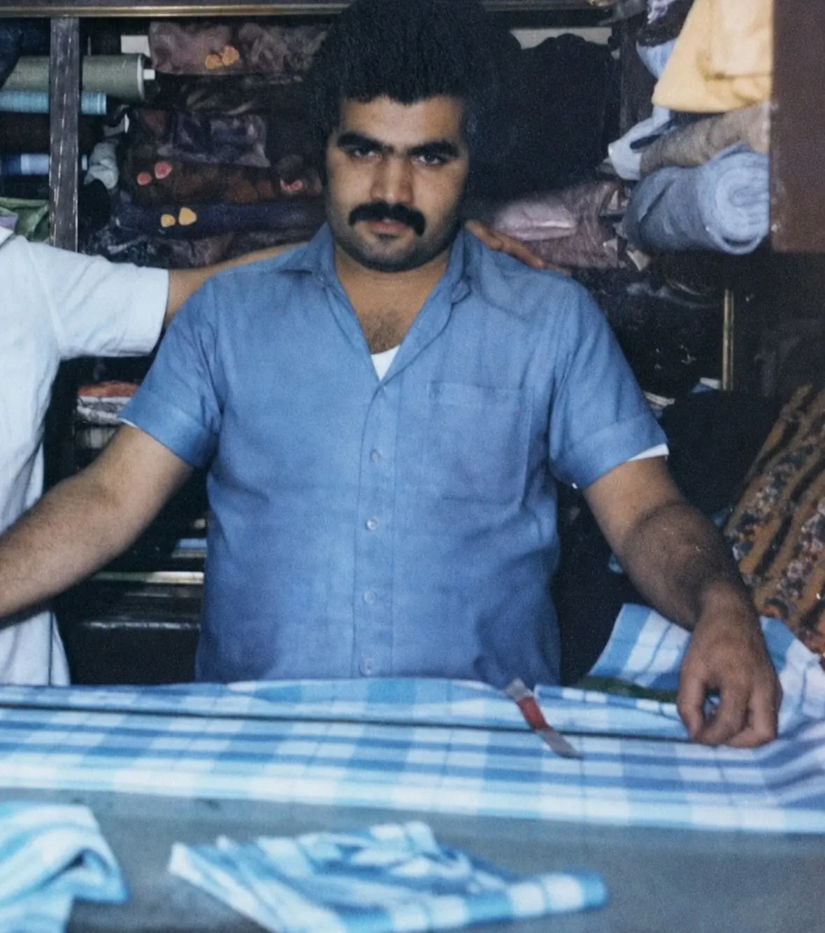 استاد خیاط نیما در کارگاه قدیمی هنگام برش پارچه
